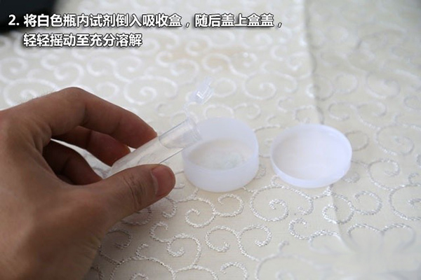 2、将白色瓶内试剂导入吸收盒,随后盖上盒盖,轻轻摇动至充分溶解